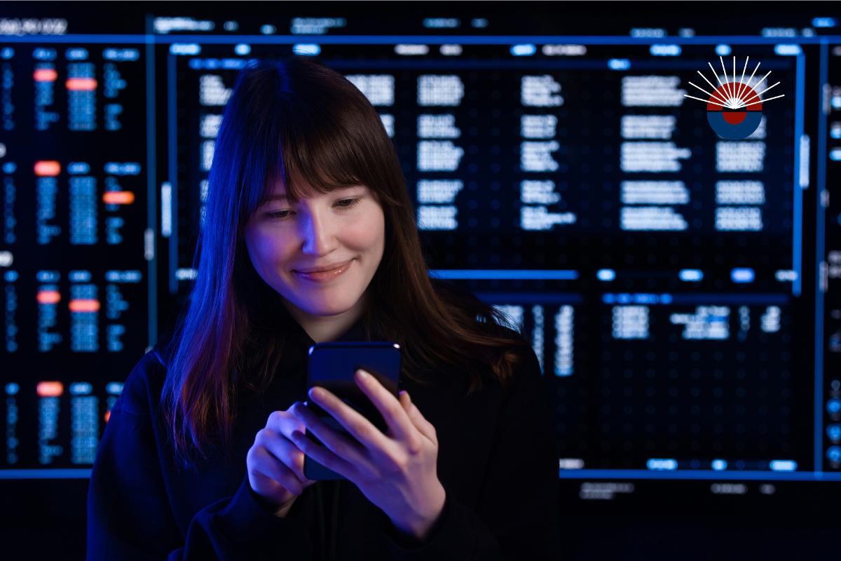 phone, fintech notebook, and coffee cup on table, with a hand over the notebook with a pen.